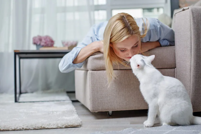 Woman cuddling with her indoor cat